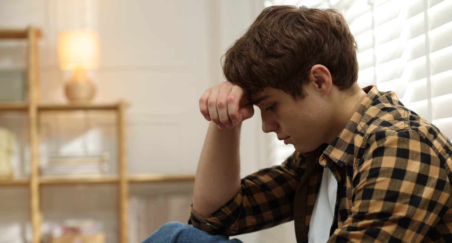 Teenage boy looking anxious and sitting down